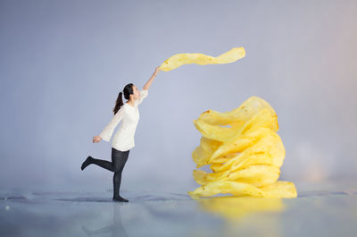 Digital composite image of young woman holding potato chips