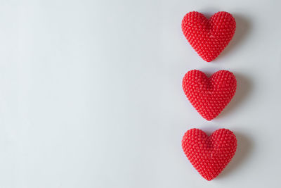 Close-up of red heart shape over white background