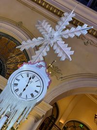 Low angle view of clock on ceiling in building