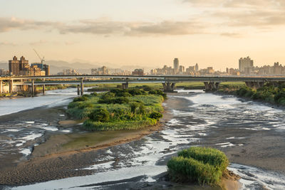 View of bridge over river against cloudy sky