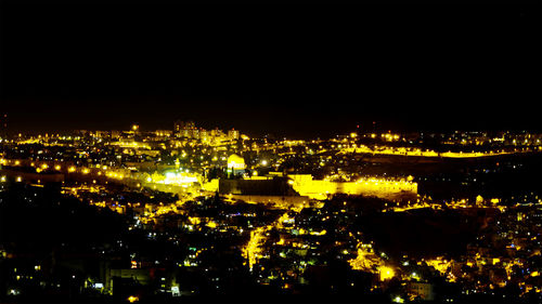 Illuminated cityscape against sky at night