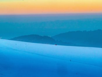 Scenic view of snowcapped mountains against blue sky