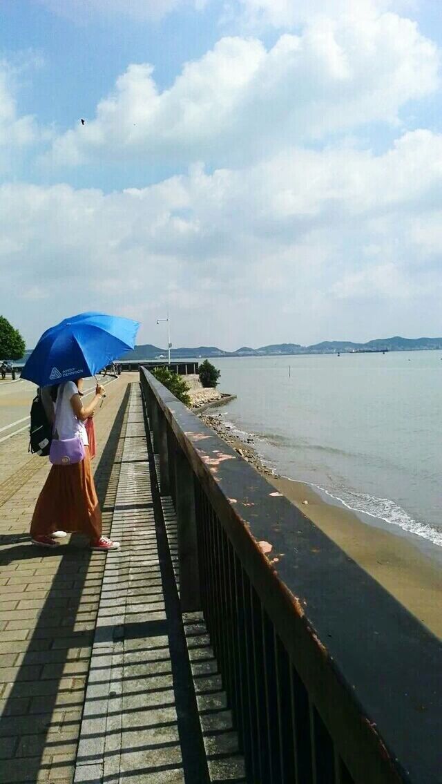 sea, sky, water, horizon over water, lifestyles, full length, cloud - sky, rear view, men, leisure activity, walking, railing, pier, beach, cloud, built structure, shore, standing