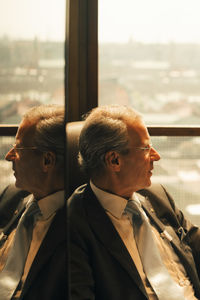 Thoughtful lawyer sitting by window at law office