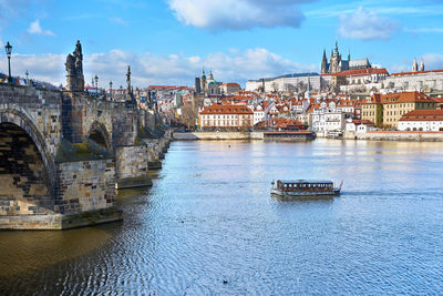 River amidst buildings in city against sky