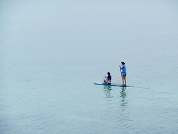 People standing in sea against sky