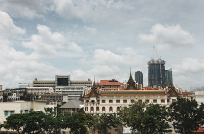 View of cityscape against cloudy sky