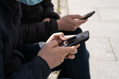 Midsection of man using mobile phone