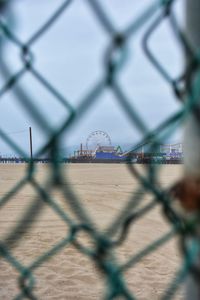 View of amusement park seen through chainlink fence