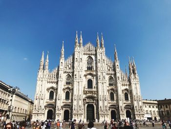 Group of people in front of cathedral against blue sky