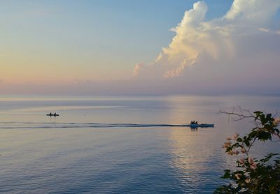 Boat sailing in sea at sunset