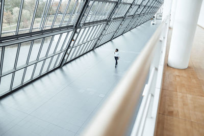 Young male entrepreneur walking by roof in office corridor