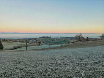 Scenic view of field against clear sky during sunset