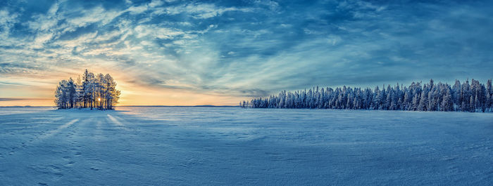 Scenic view of snow covered land against sky