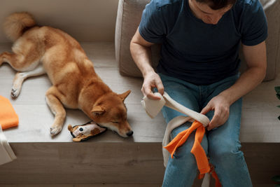 Adult man making diy homemade educational toys for dogs using a tutorial from the internet