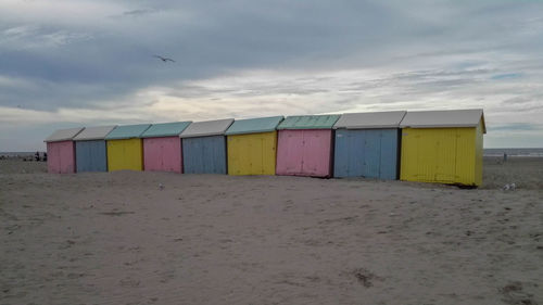 Multi colored umbrellas on beach against sky