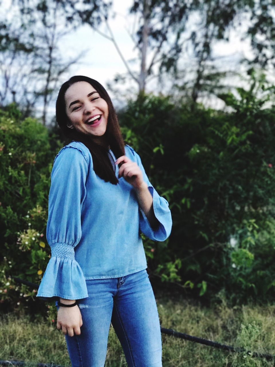 portrait, smiling, casual clothing, one person, jeans, one woman only, looking at camera, beauty, young adult, outdoors, one young woman only, leisure activity, only women, recreational pursuit, people, lifestyles, adult, adults only, standing, happiness, nature, cheerful, young women, women, beautiful woman, tree, day