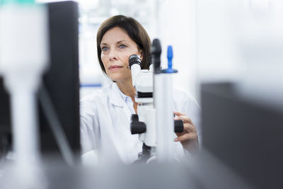 Female scientist with microscope at laboratory