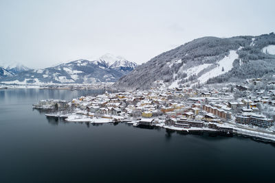 Aerial view of lake by snowcapped mountains against sky