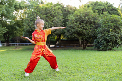 Full length of boy playing with ball on field