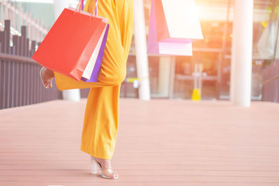 Low section of woman standing on footpath