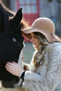 Close-up of young woman with horse