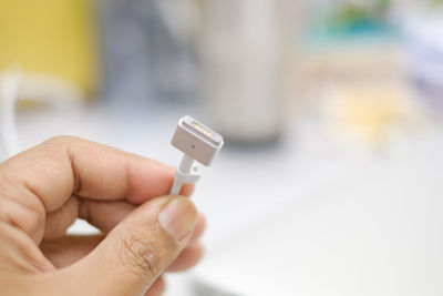 Close-up of hand holding electric plug