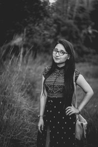 Smiling young woman standing on field