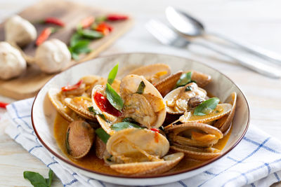 Fried clams with chilli paste on a white wooden table