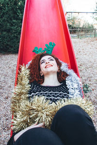 Portrait of smiling woman in slide at park