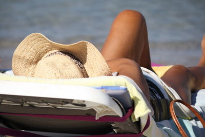 Mature woman lying on lounge chair at beach