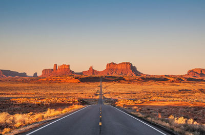 Road leading towards mountains against sky