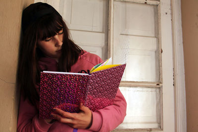 Young woman holding book at home