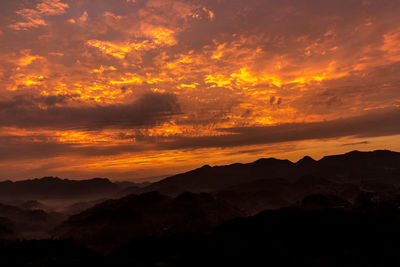 Scenic view of mountains against orange sky