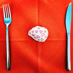 Heart shape drawing on stone amidst fork and table knife