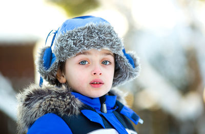 Portrait of a boy 6 years old in warm clothes in winter