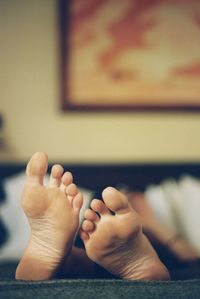 Low section of man lying on bed