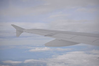Close-up of airplane wing flying over clouds