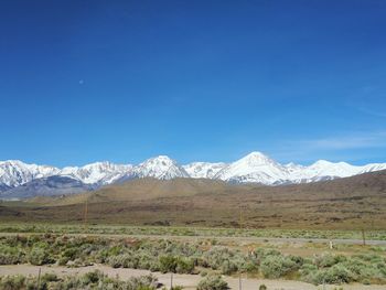 Scenic view of snowcapped mountains against blue sky