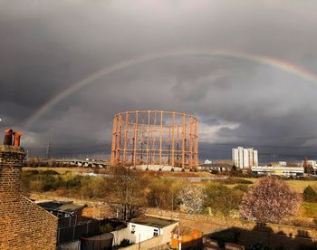 Rainbow over buildings in city against sky