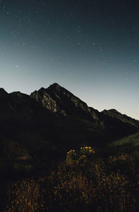 Low angle view of silhouette mountains against sky at night