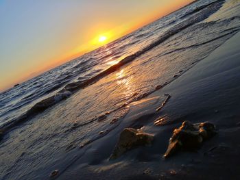 Close-up of frozen sea against orange sky