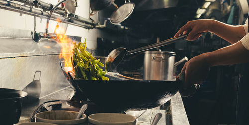 Chef stir fry busy cooking in kitchen. chef stir fry the food in a frying pan