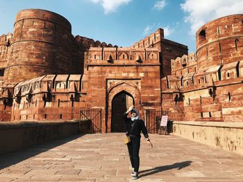 Full length of woman standing against agra fort