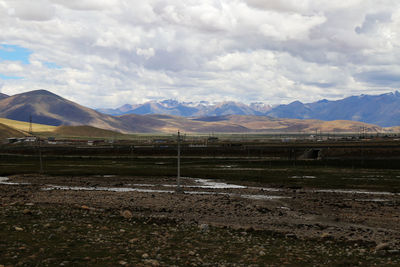 Scenic view of mountains against cloudy sky