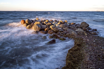 Rocks in sea against sky