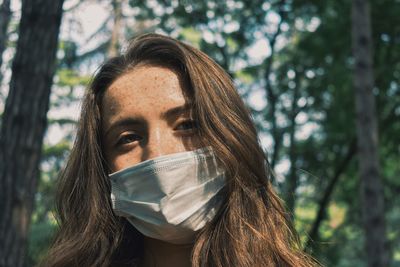 Portrait of young woman against tree