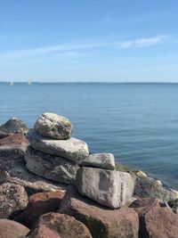 Rocks on sea shore against sky