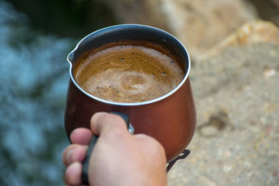 Cropped hand holding coffee cup