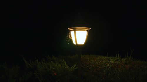 Illuminated lamp on field at night